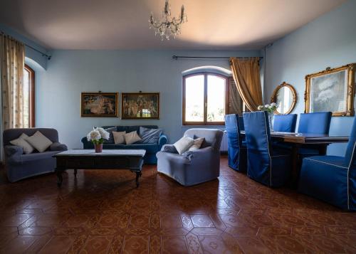 a living room with blue chairs and a table at Casa Clara in Montecchio