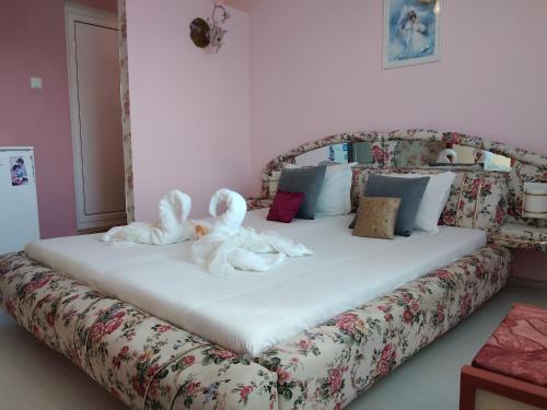two stuffed animals are sitting on a bed at Къща за гости Синьо Лято in Pomorie