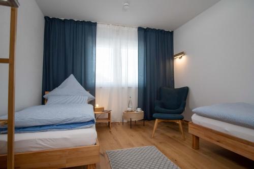 een slaapkamer met een bed, een stoel en een raam bij Ferienwohnung FühlDichWohl in Übersee