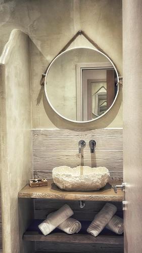 a bathroom with a sink and a mirror at Scarabeo Suites & Villas Parga in Parga