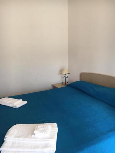 un letto blu con due asciugamani sopra in una stanza di Appartamento di Lampedusa a Lampedusa