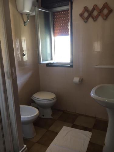 bagno con servizi igienici, lavandino e finestra di Appartamento di Lampedusa a Lampedusa