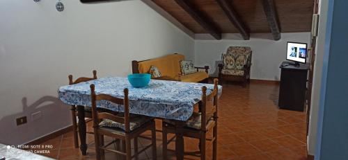 una mesa de comedor con sillas y un tazón azul. en Casa vacanze BY THE SEA en Trabia