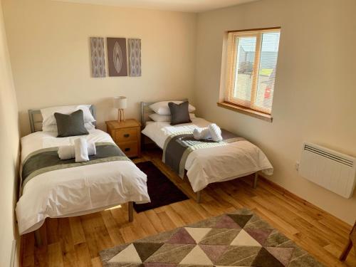 A bed or beds in a room at Eastbrae Cottages & Lodges