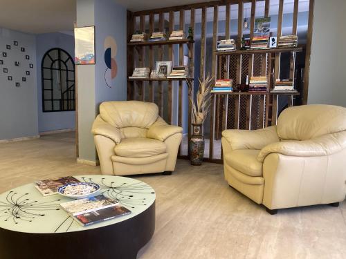 a living room with two chairs and a coffee table at Olimpia Hotel in Fethiye