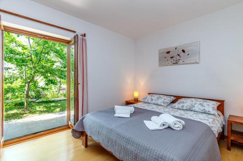 a bedroom with a bed and a large window at Apartments Lavanda in Rovinj