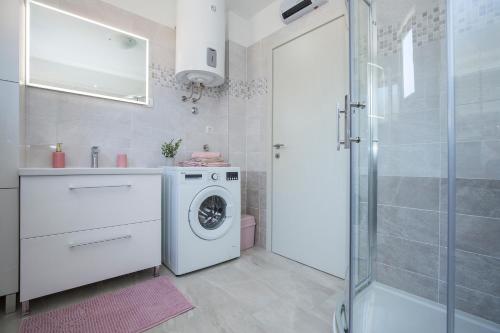 a bathroom with a washing machine and a shower at Apartment Stella in Labin