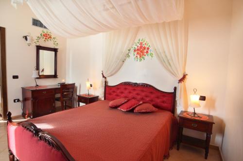 a bedroom with a red bed with two tables and a mirror at Venus Park Hotel in Castel Volturno