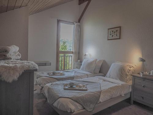- une chambre avec 2 lits et une fenêtre dans l'établissement La Belle Maison, à Peisey-Nancroix