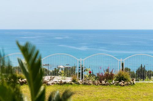 a fence with a view of the ocean at Bella Vista Stegna in Archangelos