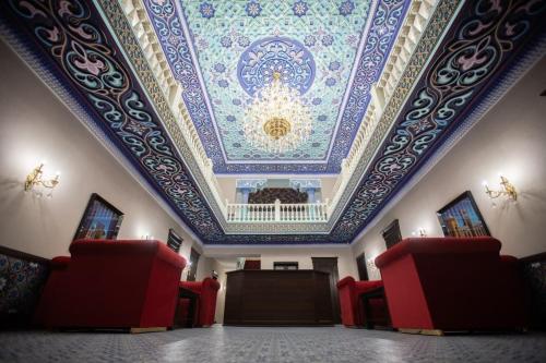 a room with a coffered ceiling and red chairs at The Shahar in Tashkent
