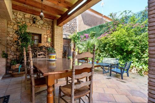 een houten tafel en stoelen op een patio bij Hauzify I Palauet del Remei in Perelló