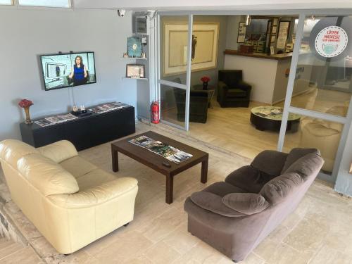 a living room with two couches and a coffee table at Olimpia Hotel in Fethiye