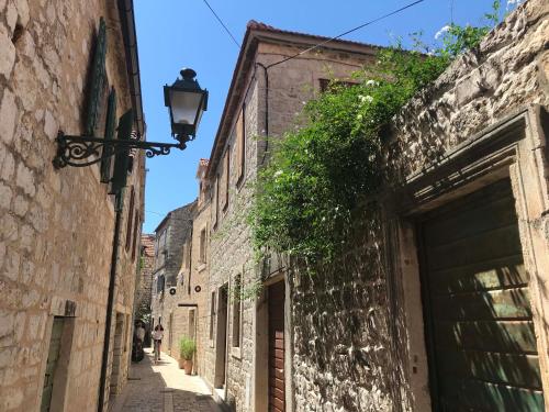 un callejón en un edificio antiguo con luz de la calle en Olive Tree en Stari Grad