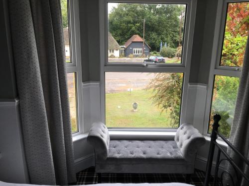 a window with a couch in front of two windows at Twin Oaks Guest House in Cadnam