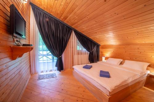 een slaapkamer met een bed in een houten kamer bij Villa Zarina in Goeta