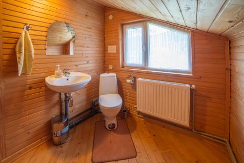 Un baño con lavabo, inodoro y ventana. en Villa Zarina, en Guta