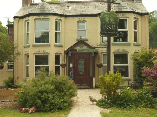 a large house with a sign in front of it at Twin Oaks Guest House in Cadnam