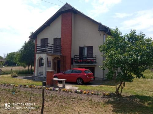 a red car parked in front of a house at Vila Milica in Kraljevo