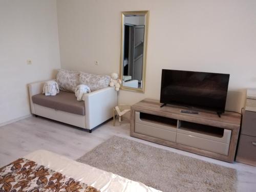 a living room with a flat screen tv and a couch at Къща за гости Синьо Лято in Pomorie