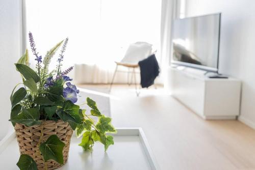 um vaso de flores sentado numa mesa numa sala de estar em Apartment Sleepwell, Leppävaara, 71m2 with private sauna em Espoo