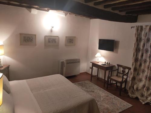 a bedroom with a bed and a desk and a television at Tenuta Mocajo in Guardistallo