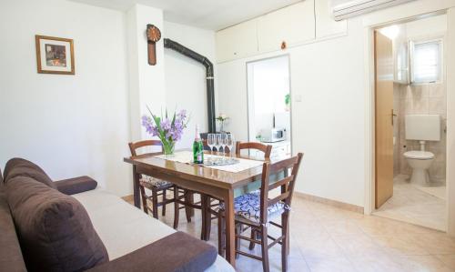 a kitchen and dining room with a table and chairs at House with large garden right next to the river in Žrnovnica