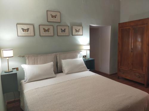 a bedroom with a bed with white sheets and pillows at Tenuta Mocajo in Guardistallo