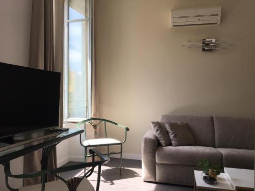 a living room with a couch and a tv at Palais Gioffredo place Massena in Nice