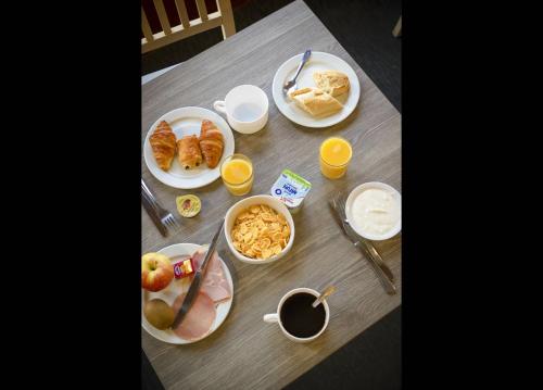 un tavolo ricoperto di piatti per la colazione e succo d'arancia di VVF Serre Chevalier Briançon a Le Monêtier-les-Bains