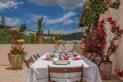 a table with wine glasses and flowers on a patio at Villa Phoenix in Keri
