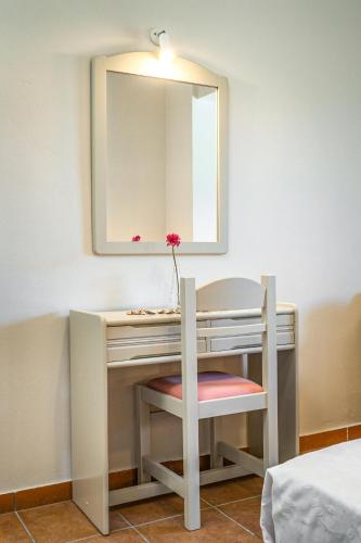 a dressing table with a chair and a mirror at Villa Phoenix in Keri