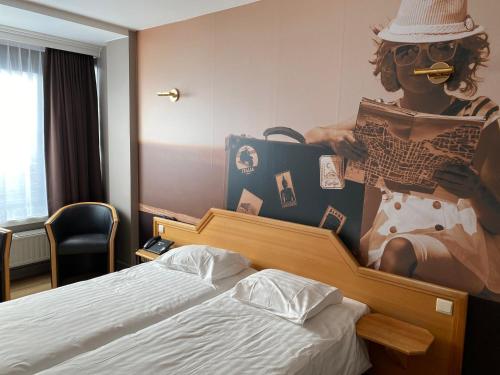 a bedroom with a bed with a painting of a woman at Liberty in Blankenberge