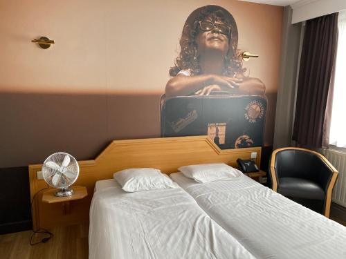 a bedroom with a large picture of a woman on the wall at Liberty in Blankenberge