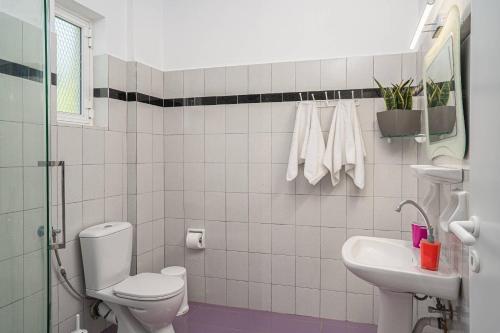 a white bathroom with a toilet and a sink at Villa Phoenix in Keri