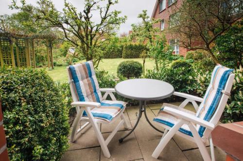 two chairs and a table on a patio at Hotel Schiffer in Bensersiel