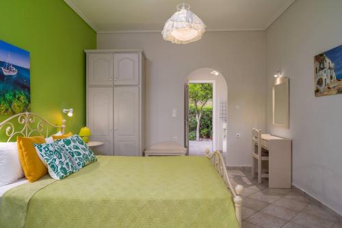 a bedroom with a bed with a green wall at Villa Phoenix in Keri