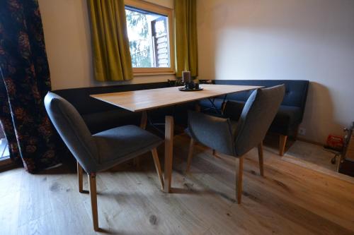 a dining room table and chairs in a room with a window at Berghaus Turracherhöhe in Turracher Hohe
