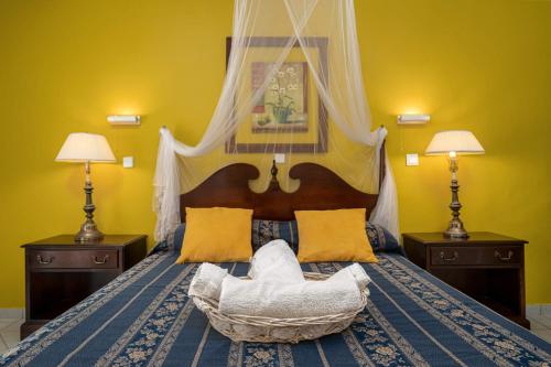 a bedroom with a large bed with two lamps and a chair at Villa Phoenix in Keri