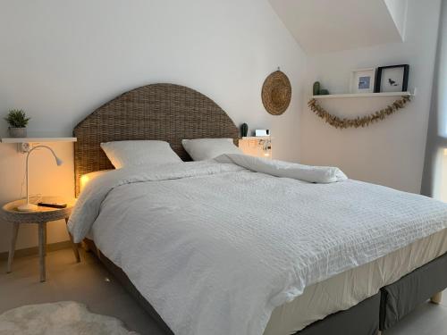 una camera da letto con un grande letto con lenzuola e cuscini bianchi di Penthouse Las 2 Salchichas a San Javier