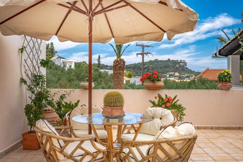 a table and chairs with an umbrella on a patio at Villa Phoenix in Keri