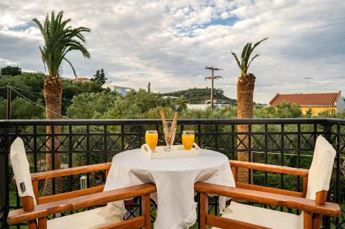 a table with drinks on a balcony with palm trees at Villa Phoenix in Keri