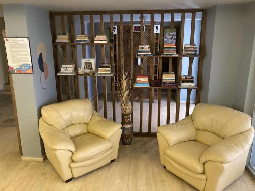 two chairs and a book shelf with books at Olimpia Hotel in Fethiye