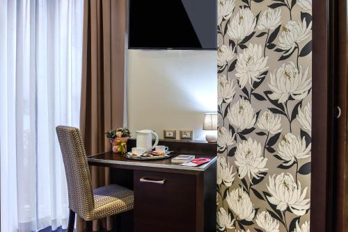 a room with a desk and a chair in a room at Catone District Hotel in Rome