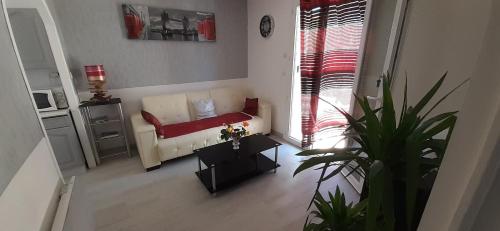 un salon avec un canapé et une table dans l'établissement appartement bien équipé 2 chambres lit 2 place, plus canapé lit, 5 personnes, terrasse bien équipé, planchas, parking gratuit sur place, a proximité de tout commerce et de cure thermal, Cadarache ,Forcalquier, gorge du verdon , Moustier, montagne de Lure, à Volx