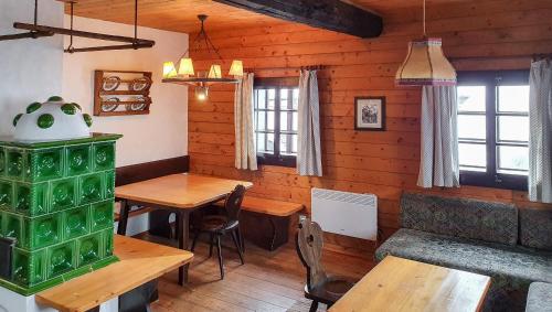 ein Esszimmer mit Holzwänden, Tischen und Fenstern in der Unterkunft Apartment Sophia in Sonnenalpe Nassfeld