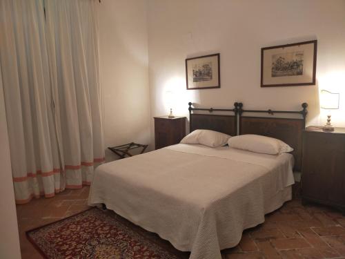 a bedroom with a large bed with two pillows at Tenuta Mocajo in Guardistallo