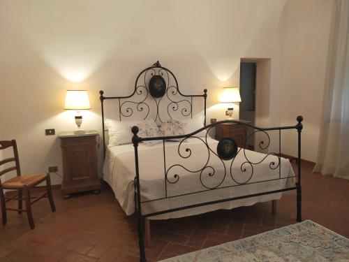 a bedroom with a bed and two lamps and a chair at Tenuta Mocajo in Guardistallo