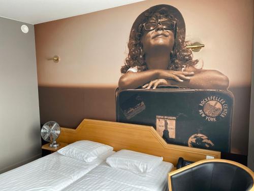 a woman sitting in a suitcase on top of a bed at Liberty in Blankenberge