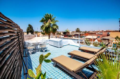 einen Pool mit Liegestühlen und Stühlen auf einer Terrasse in der Unterkunft Hotel & Spa Riad Dar El Aila in Marrakesch